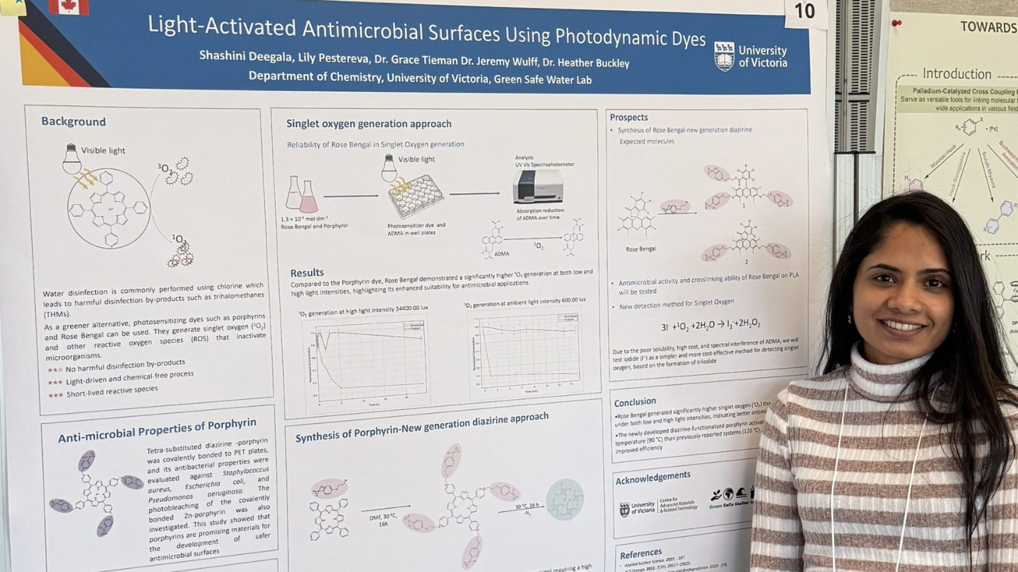 A woman stands next to a posterboard with graphics.