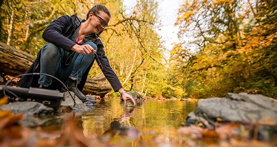 Camille Zimmer (civil engineering) is taking water samples in Goldstream Park.
