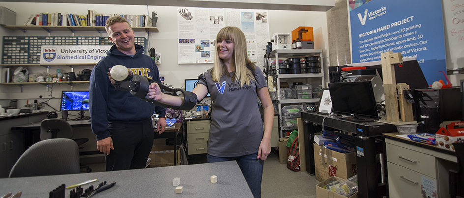 Two people testing a prosthetic arm in a UVic lab