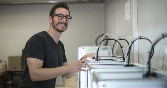 Michael Peirone using a 3D printer in a UVic lab