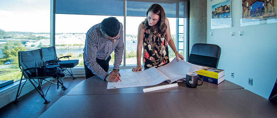 UVic alumna Elodie Forest looking at blueprints with a colleague