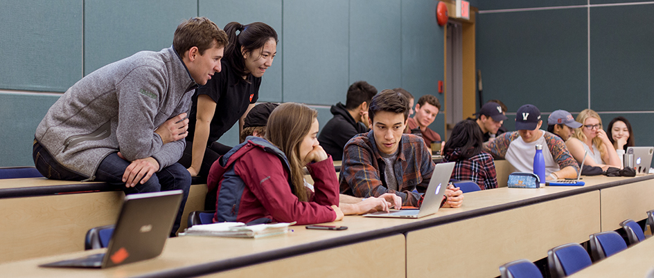 UVic students in a classroom looking at a laptop