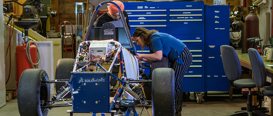 UVic student Tylynn Haddow working on a hybrid race car in a garage