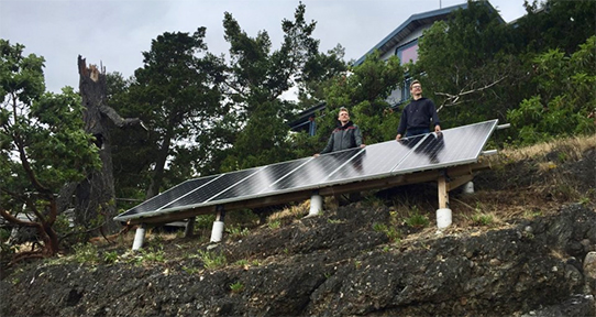 Two co-op students working on a cabin's solar panel