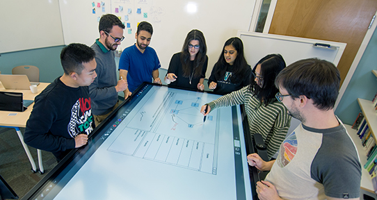 Students collaborating in a work space with a smart table