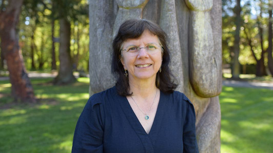 A portrait of Dr. Anita Prest outdoors on campus at UVic on a sunny day.