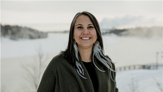 Belinda Daniels is photographed outdoors on a snowy day, she is smiling at the camera.