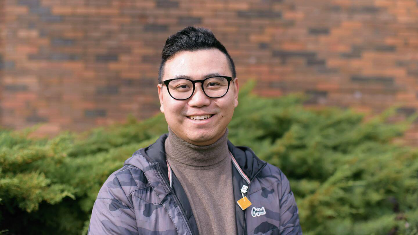 A portrait of graduate student Allen Sun, pictured outside the MacLaurin Building on a sunny day.