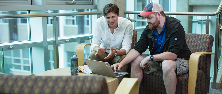 Two men in the UVic library looking at a laptop screen