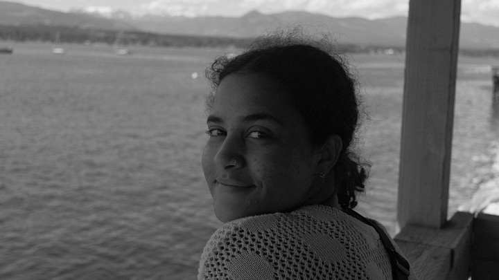Black and white image of Carys Mitchell in front of the ocean.