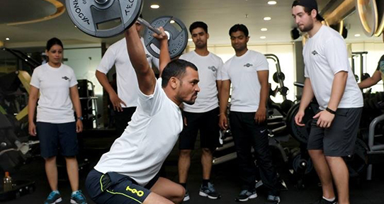 People lifting weights in a gym in India