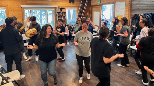 A group of students and community members dance together with drummers