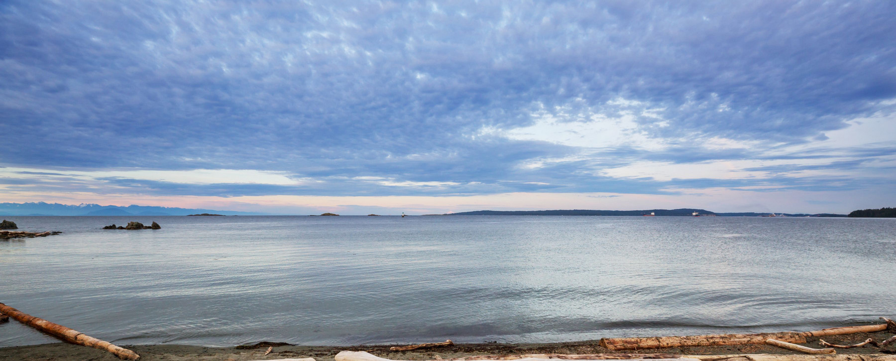 A peaceful west coast beach scene at dawn, looking out over the water from the beach.