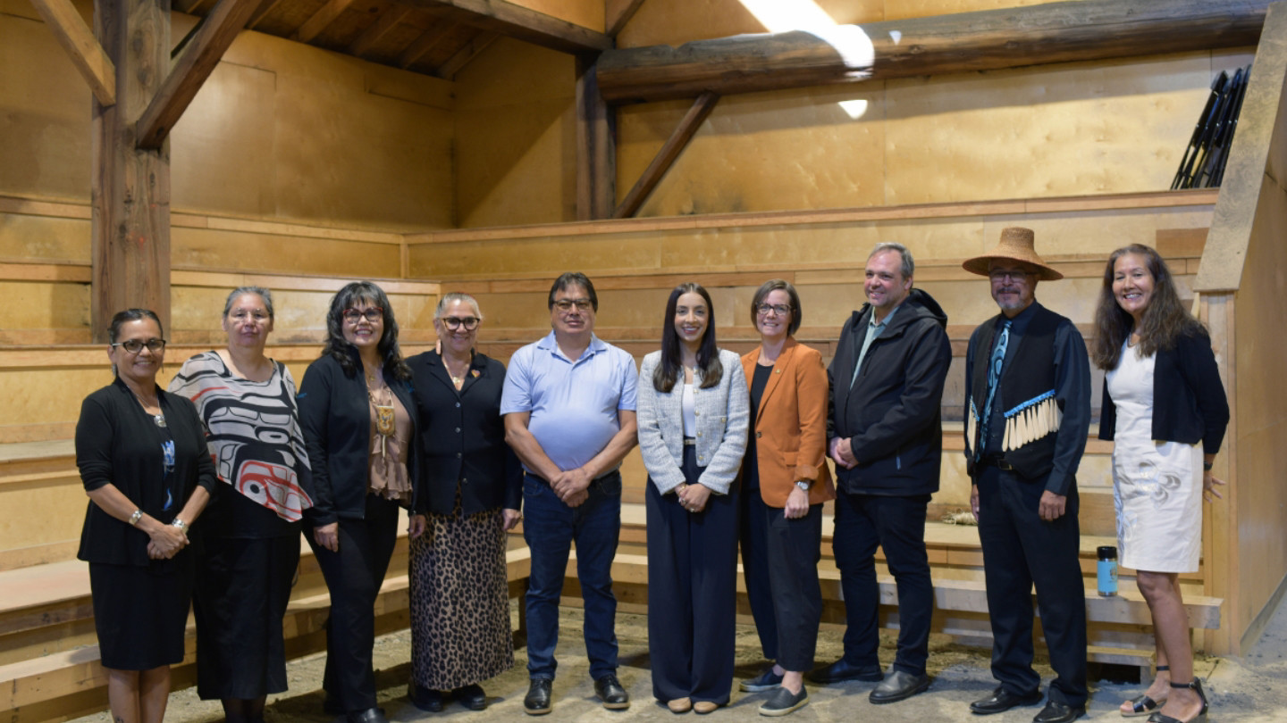 A group of partners from UVic, the Ministry, FNESC, and Stz'uminus First Nation gather together to acknowledge the funding announcement in Stz'uminus Big House.