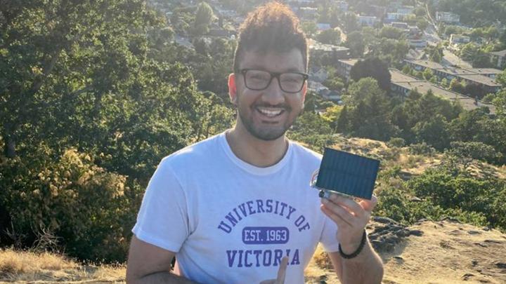 student holding small solar panel