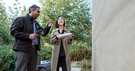 Professor and student examine a rammed earth wall