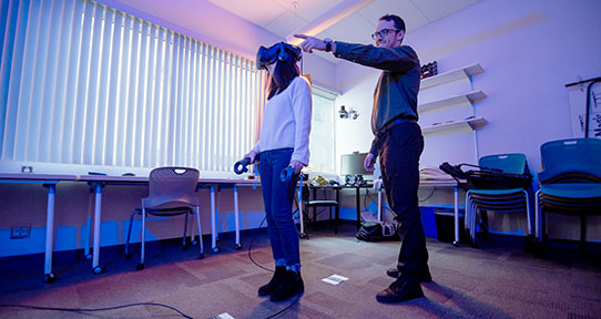 Graduate students Jorin Weatherston and Ying Wang using a virtual reality set