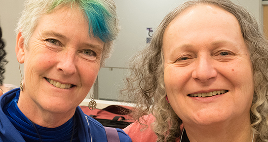Faces of two people smiling.