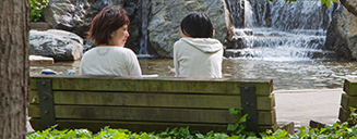 Two women talking on a bench by the fountain