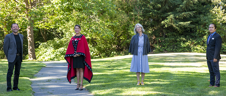 Former UVic President and Vice-Chancellor, Jamie Cassels, Minister Mark, Director of the Indigenous Law Program, Val Napoleon and Councillor Garry Sam, Songhees Nation stand 6ft apart on the lawn at UVic campus