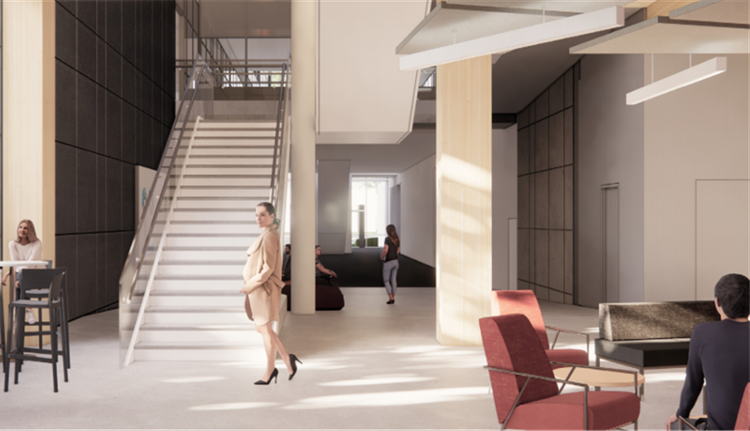 A lounge area populated with people and chairs, located under a concrete staircase.