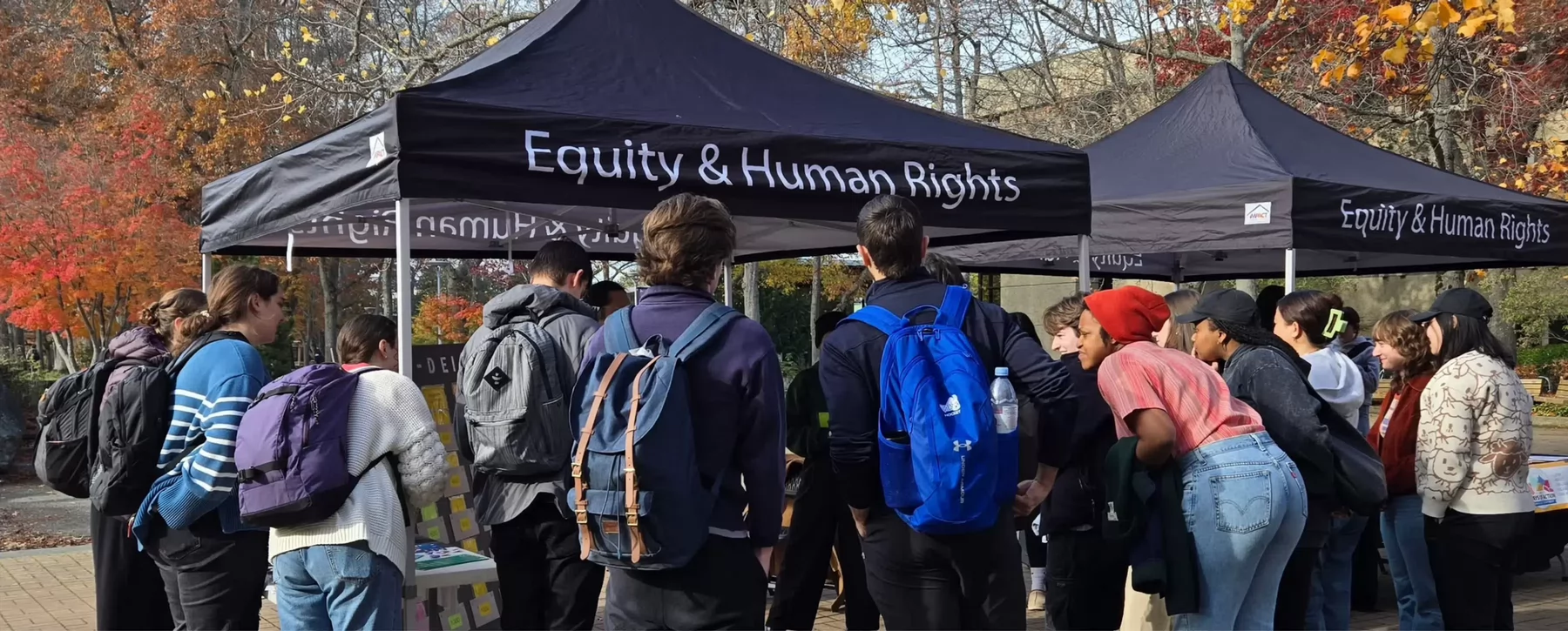 A group of students gather around a table on campus.
