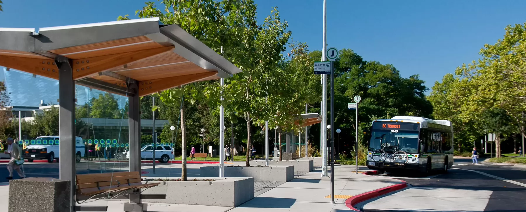 A BC transit bus parked at a bus stop at the UVic bus loop on campus. 
