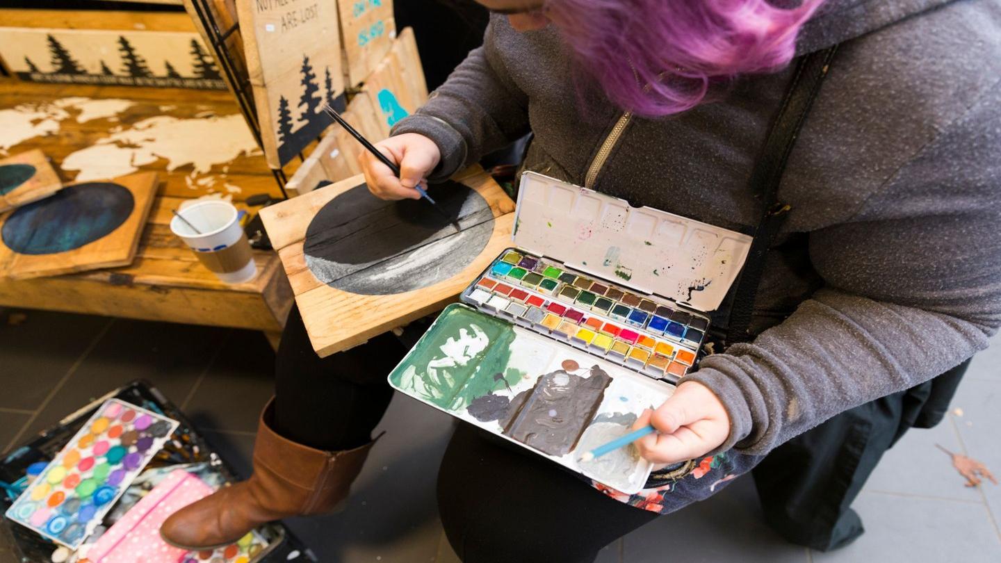 An artisan painting a wood ornament