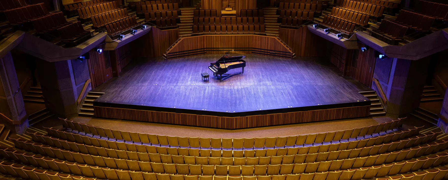 Farquhar theatre stage with a piano and purple lighting.