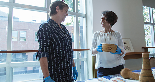 Two women looking at artifacts together