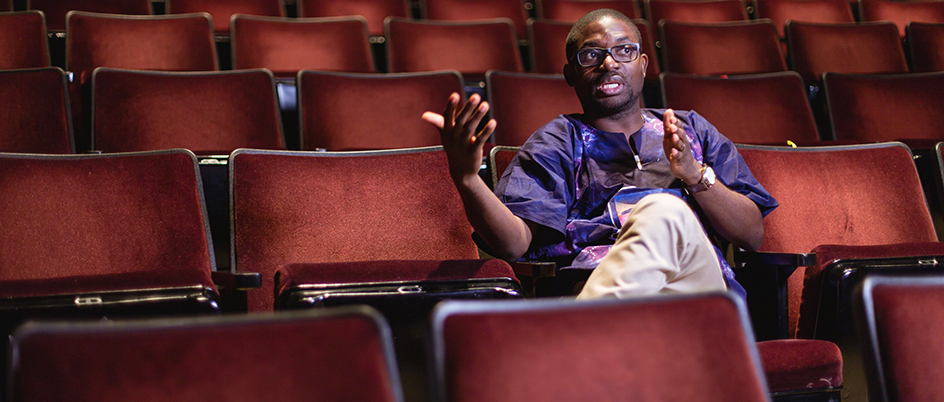 Graduate student Taiwo Afolabi sitting in a theatre