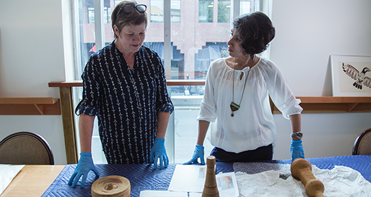 Two women looking at old artifacts