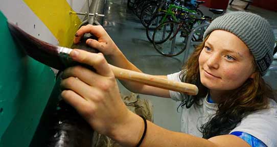 Student painting a wall mural