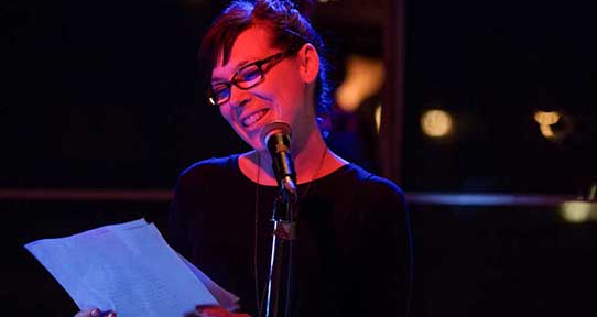 Student reading from a sheet into a microphone