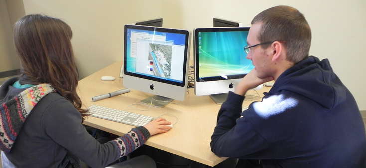 Student and professor use a computer together