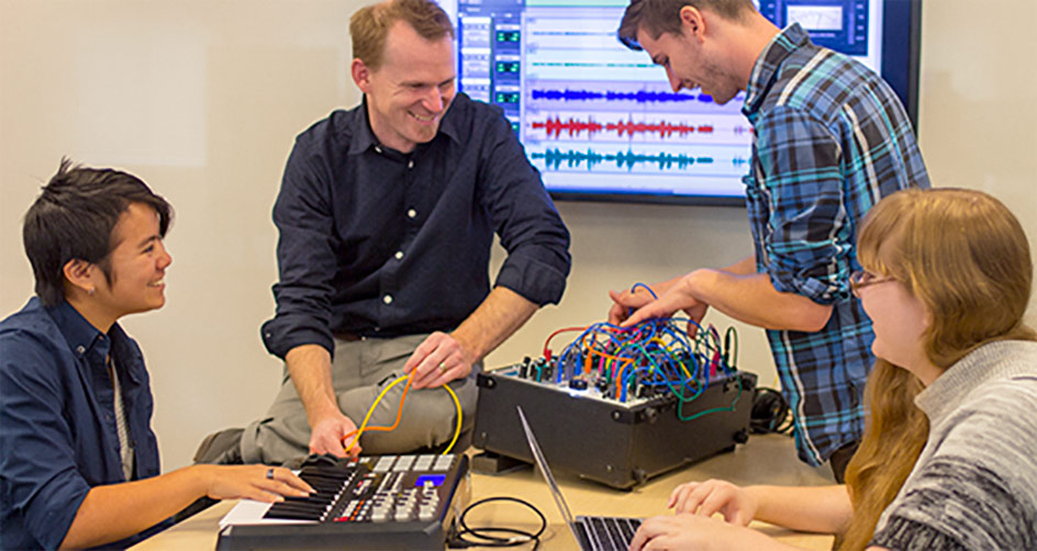 Instructor working with students on a sound board