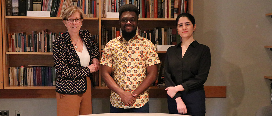 Three graduate students standing in the Phoenix Theatre library classroom.