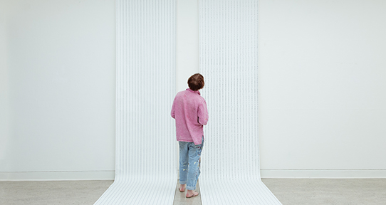 Man looking at a white wall student exhibition