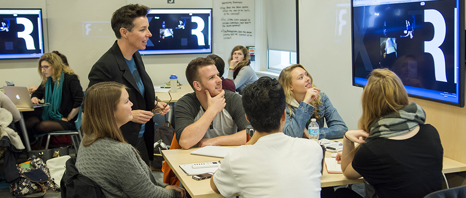 A professor talking to students in a small classroom