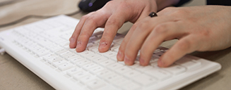 Close-up of a student typing on a computer keyboard