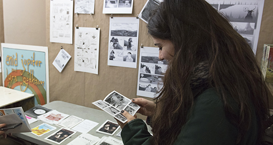 Graduate student looking at graphic novel artifacts