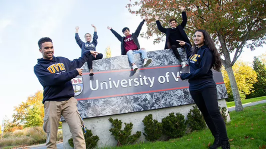 Group of students on the UVic sign