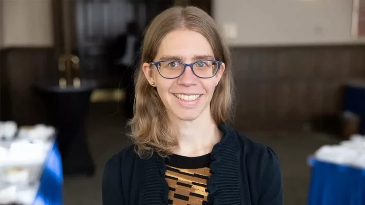 Woman with shoulder length hair and glasses smiling.