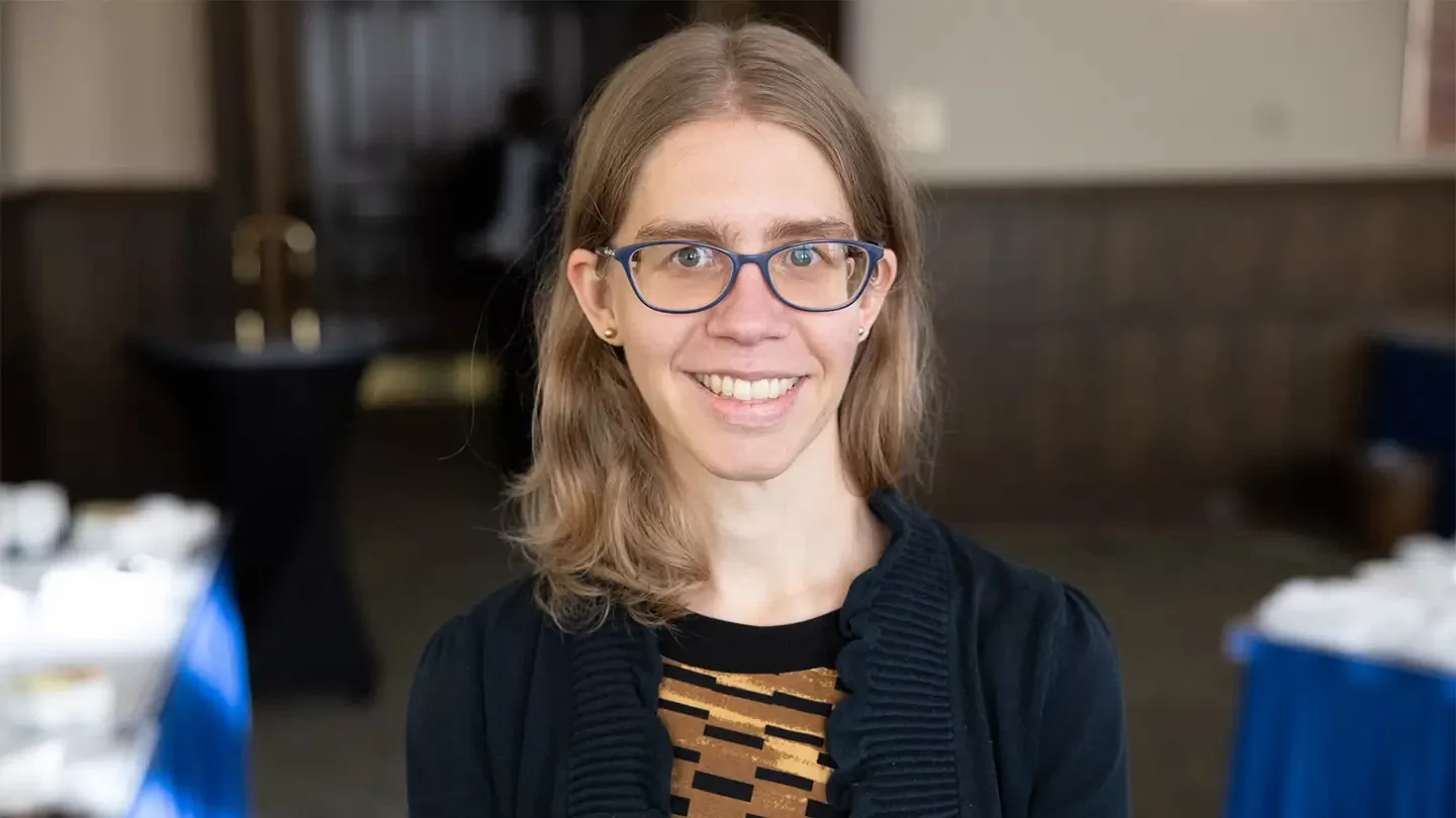Woman with shoulder length hair and glasses smiling.  