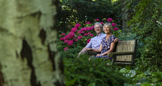 Claire and Will Cupples sit together on a bench in Finnerty Gardens