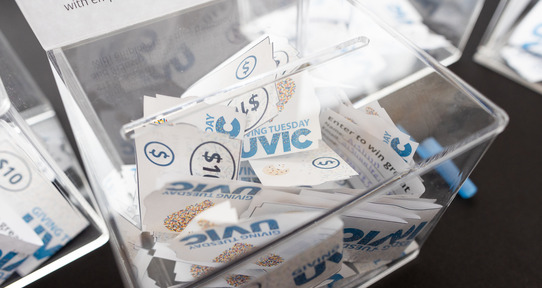 clear box filled with UVic sprinkle bucks (fake money)