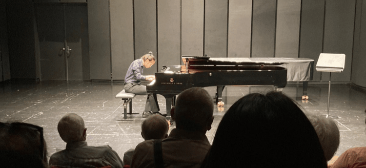 Lucas playing the piano for a crowd in Austria