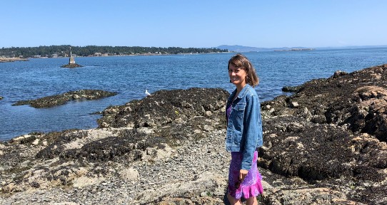 Patricia Collins stands on rocks at Cattle Point in 2019