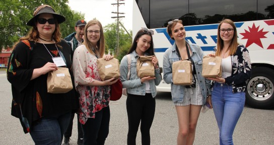 Field school participants stand by the bus