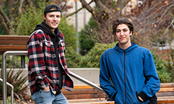 Two male students stand on the steps outside the university's Bob Wright building.